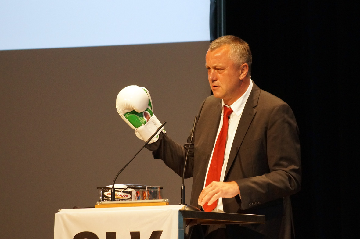 Redner mit Boxhandschuh am Pult